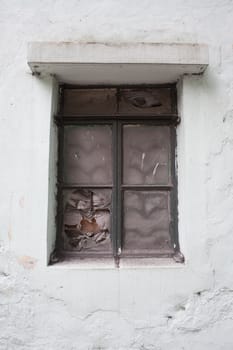 Broken glass window in old wall of abandoned house