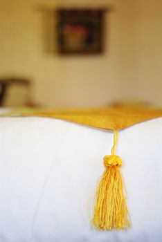 Silk yellow on white bed close up