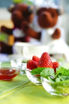 strawberries in the bowl with green fabric