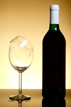 Vine bottle and broken glass on orange background