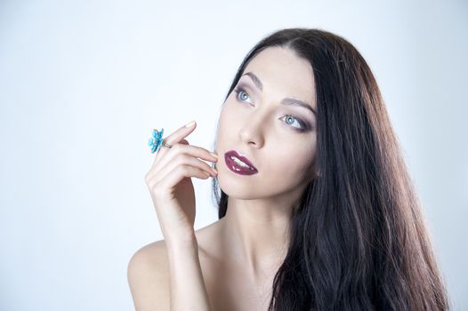 young woman with black hair and a ring on her finger