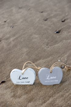 two inscribed wooden love hearts sinking in the quicksand on a wild Atlantic way Irish beach in summer