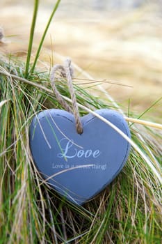 single blue wooden love heart in dunes on an Irish beach