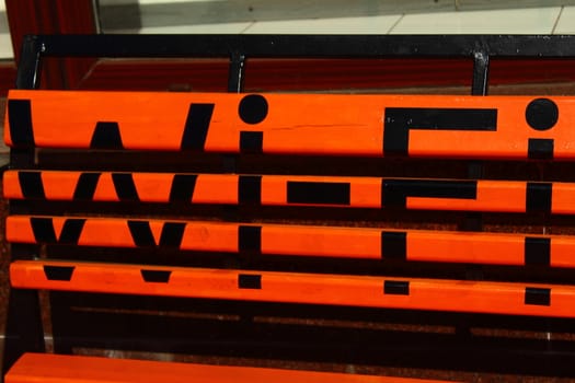 orange bench on which is written in black Wi- Fi