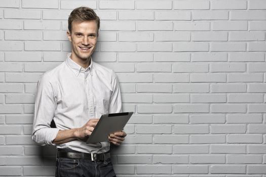 Male portrait smiling digital tablet studio brick looking camera