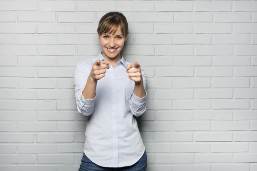 Female casual happy studio point fingers gray background