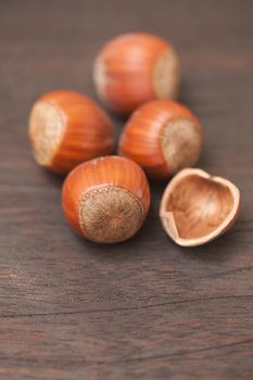 heap of hazelnuts on a wooden surface
