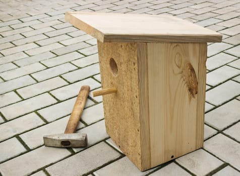 Small birdhouse from wooden planks on floor