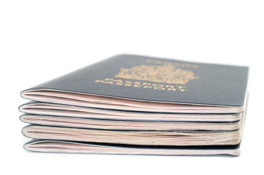 Pile of five passports viewed from the side on white background