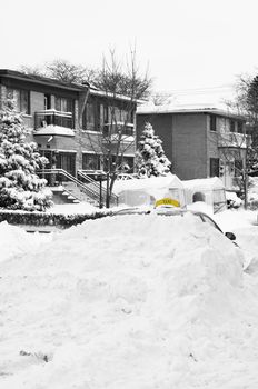 Selective color Black and white Winter scene Taxi car buried under snow in Montreal, Quebec Canada