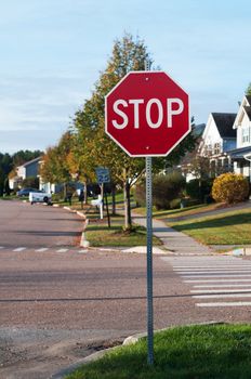 Stop sign at street corner with pedestrian cross path