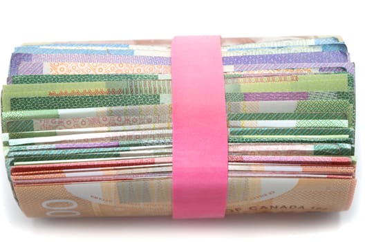 Side view of a Roll of Canadian banknotes wraped with a pink rubber band