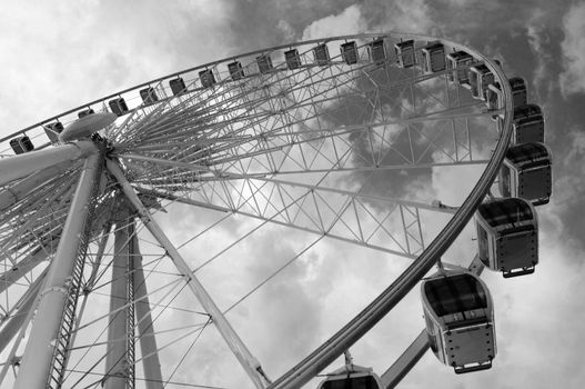 Large ferris wheel against clear blue sky in black and white
