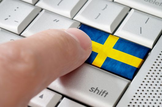 Business concept male finger pressing Sweden enter key on metallic keyboard