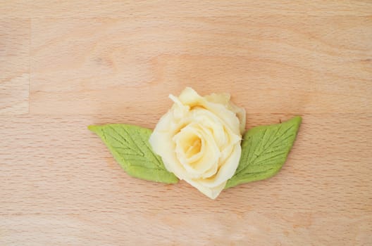 Rose made with marinated japanese  ginger and green wasabi on wooden cutting board