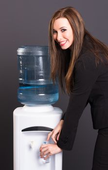 Young adult female at water cooler in workplace