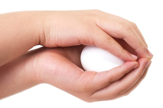 Asian boy holding an egg carefully with both hands in sign of protection on white background