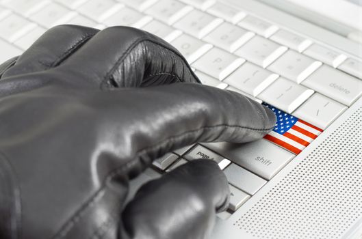 Hacking USA concept with hand wearing black leather glove pressing enter key with flag overlaid