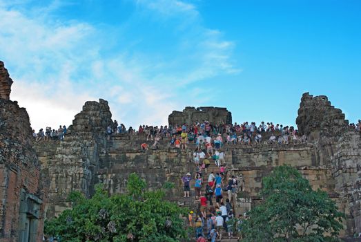 Siem Reap , CAMBODIA - MAY 02: Unidentified tourists climbing to the top of a tower at Angkor Wat to watch sunset. It is a part of the ancient Khmer complex Angkor, a UNESCO World Heritage Site, May 02, 2011, Siem Riep, Cambodia. 