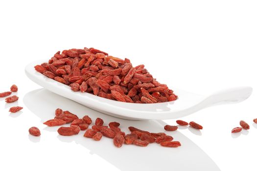 Dried goji superfood on white plate isolated on white background. Healthy superfood eating.