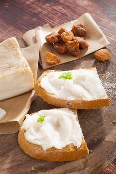 Bread slice with lard, cracklings and bacon on wooden background. Traditional culinary eating. 