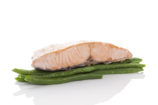 Barbecue salmon steak on green beans isolated on white background with reflection. Healthy seafood eating.