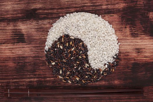 Rice variation with chopsticks on dark wooden background top view. Traditional rice eating.