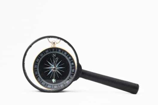 Orientation Concept - Analogic Compass and Loupe on a White Background