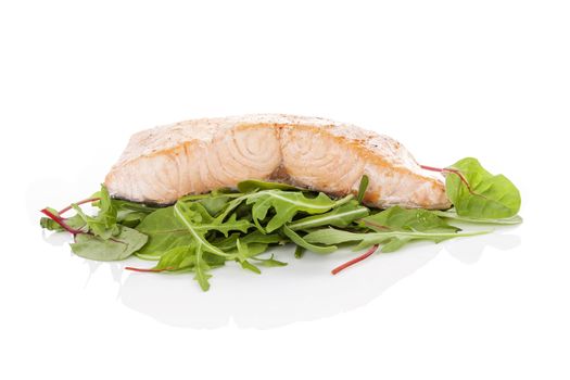Grilled salmon steak on aragula isolated on white background. Culinary seafood eating.

