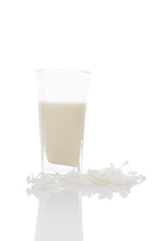 Coconut milk in glass with coconut flakes isolated on white. Vegan milk concept.