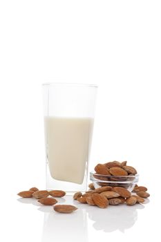 Almond milk in glass with almond nuts in glass bowl isolated on white. Vegan eating concept.