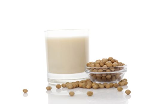 Soya milk in glass with soya beans isolated on white. Vegan milk concept.