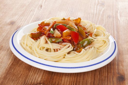 Delicious thai vegetarian pasta on white plate on wooden background. Healthy vegetarian eating.

