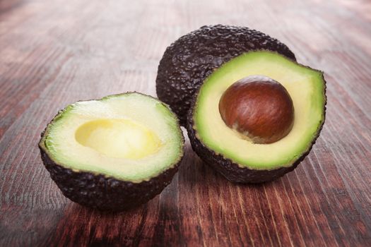 Ripe avocado on wooden background. Culinary healthy fruit eating.