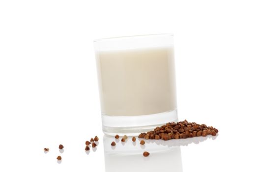 Buckwheat milk in glass with dry buckwheat seeds isolated on white background. Vegan and vegetarian milk concept.