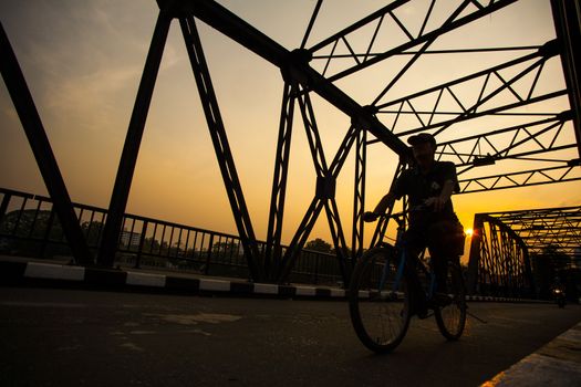 Man ride bicycle silhouette on bridge