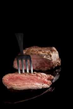 delicious medium rare sliced steak with fork 