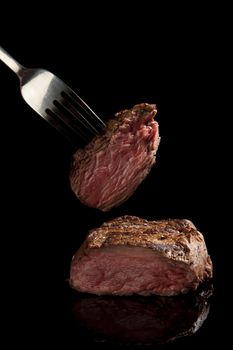 medium rare beef steak on black background.