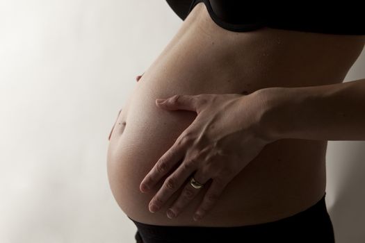 pregnant women holding belly on white background