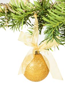 Hanging golden christmas ball on yew branch with decoration.