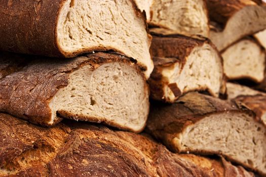 Fresh Italian ciabatta cut bread and crust background.