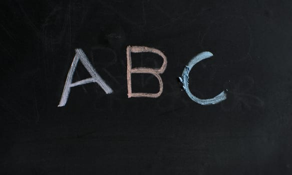 ABC colored chalk on blackboard.