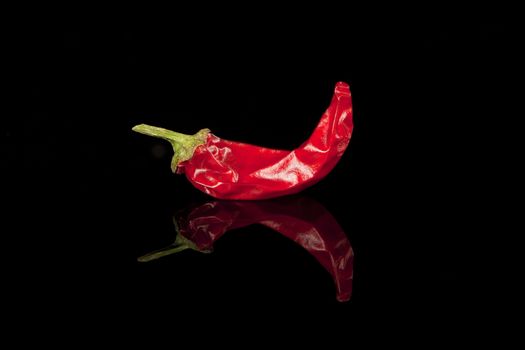 Red hot chili pepper isolated on black background.