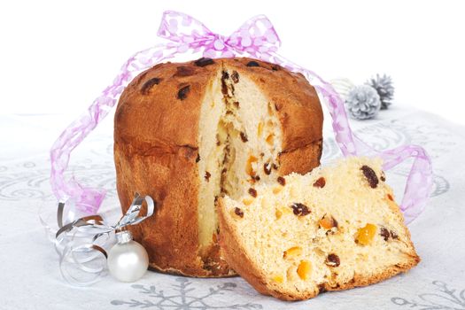 Panettone fruit cake with christmas decoration and ribbon. Festive xmas background.