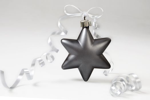 Grey christmas star with bow on white background.