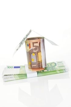 House made of 50 and 100 EUR notes isolated on white background. Home financing concept.