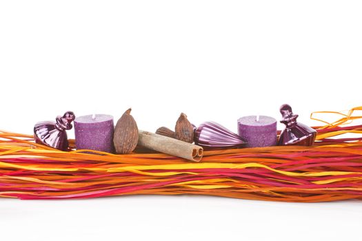 Modern christmas still life with candle, cinnamon, nutmeg and colorful branches. Contemporary xmas background.