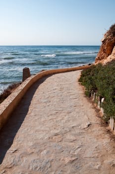 Mediterranean paved walking path with horizon and resorts in the distance in Costa Blanca, Spain.