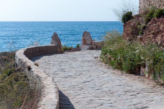 Mediterranean paved walking path with horizon and resorts in the distance in Costa Blanca, Spain.