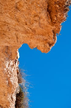 Red cliff and blue sky - vertical.